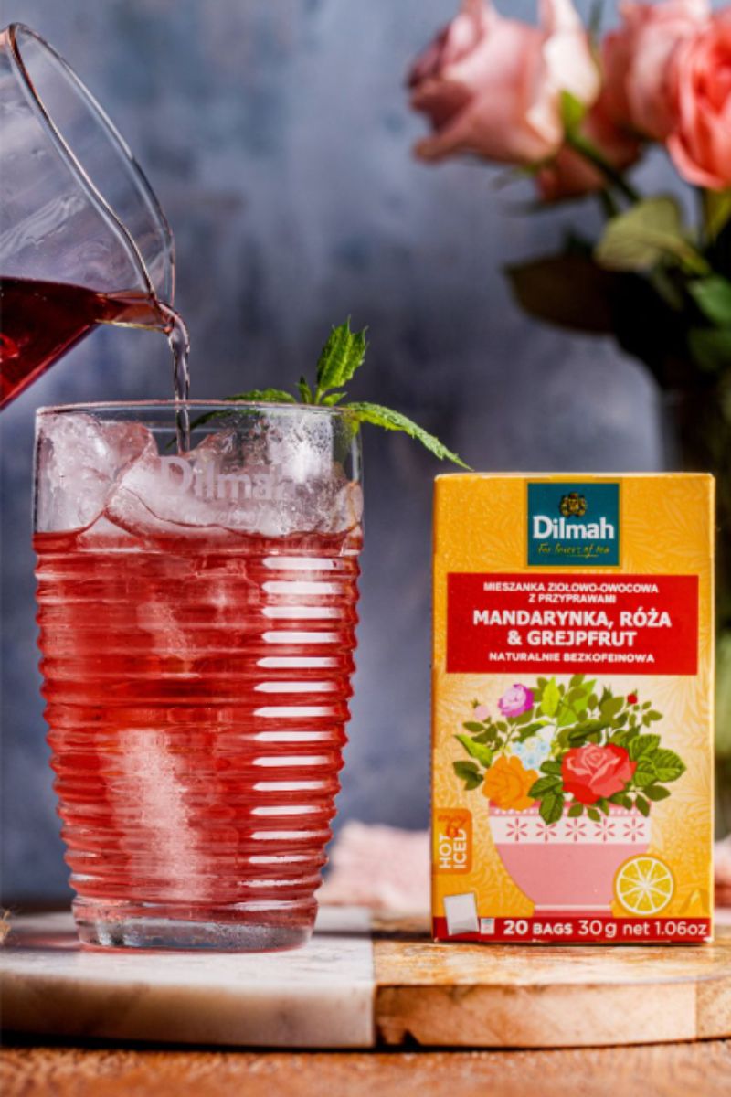 Napar Dilmah o smaku mandarynki, róży i grejpfruta. Opakowanie naparu i napój z lodem na jego bazie.
