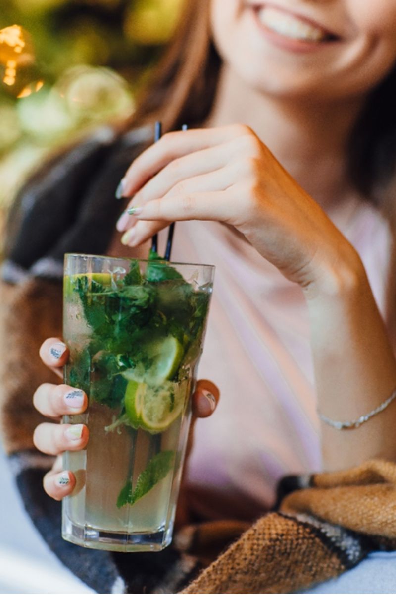 Śmiejąca się kobieta pijąca bezalkoholowe mojito na bazie syropu Fabbri Mojito.
