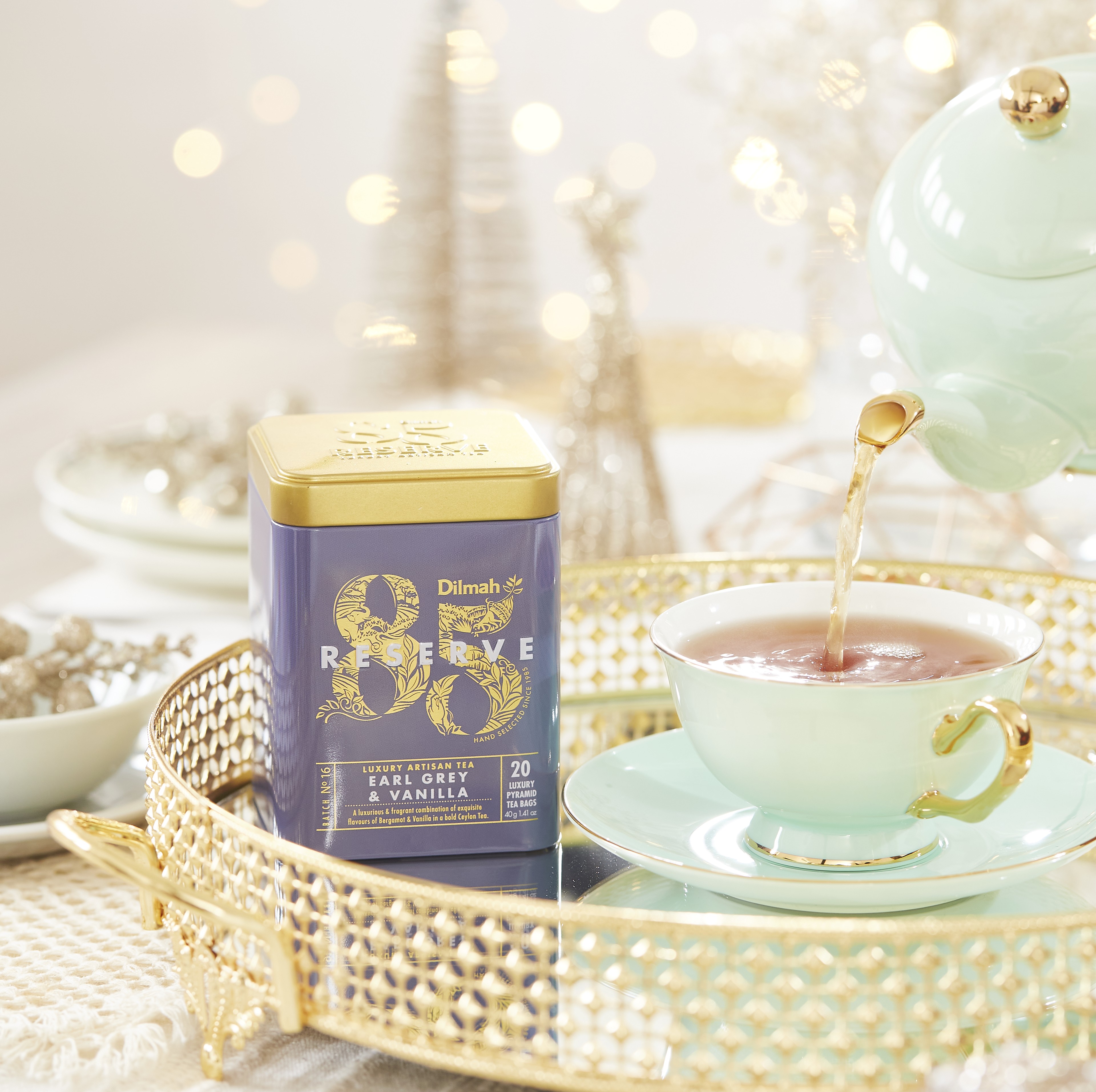 Herbata na prezent dla szefa lub szefowej Dilmah Earl Grey & Vanilla. Puszka na tacy obok filiżanki, wśród dekoracji świątecznych.