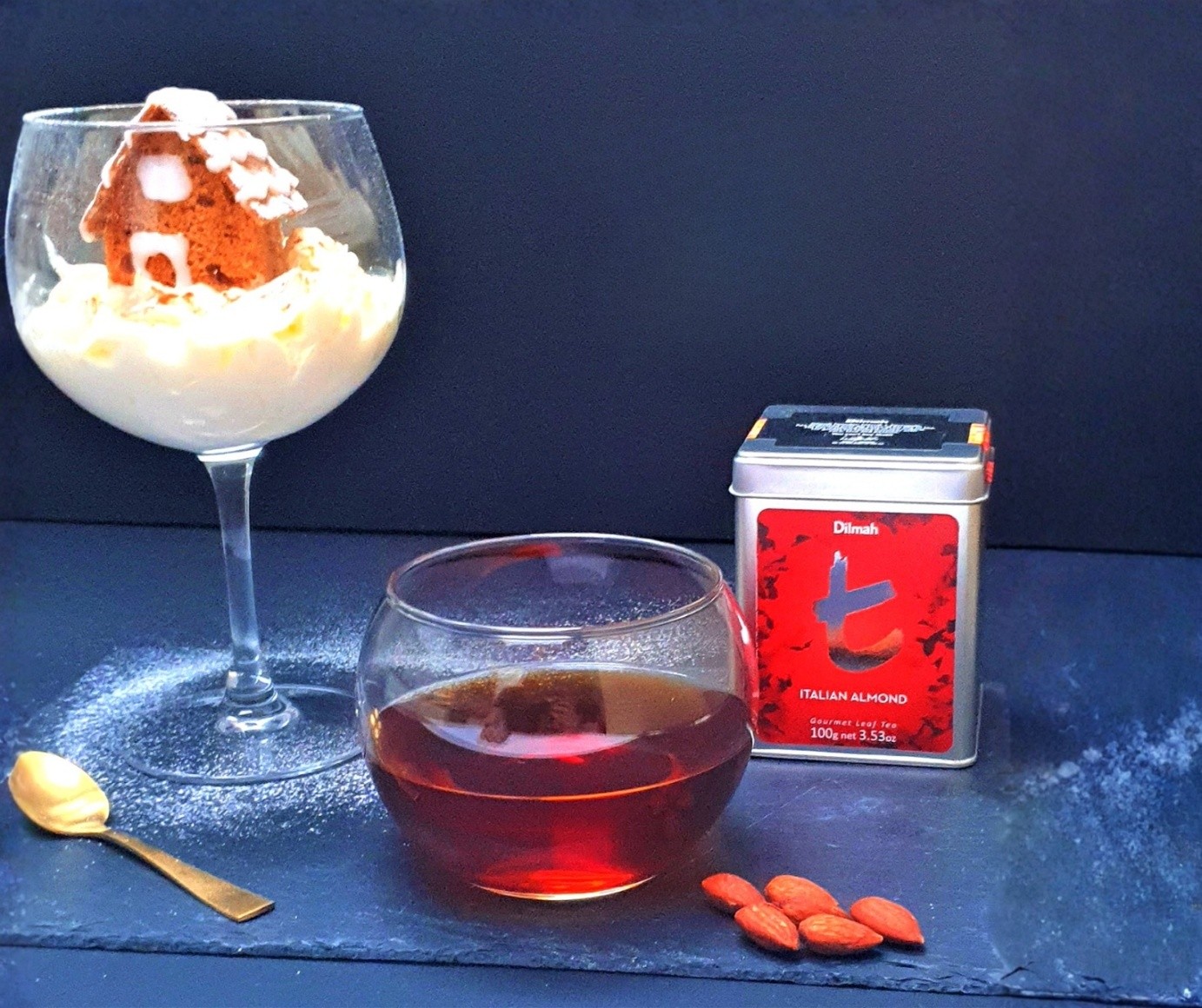ALT: Herbata w puszce Dilmah Italian Almond na prezent. Obok gotowy napar I deser z piernikiem.