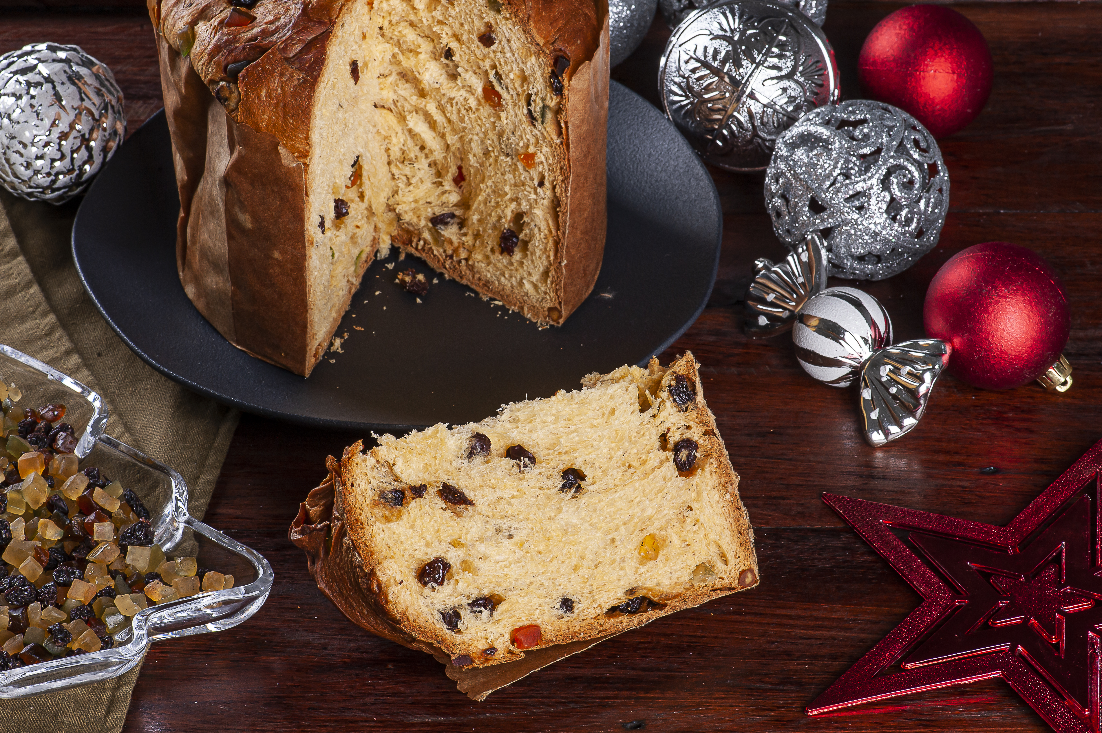 Włoski wypiek z bakaliami – babka Panettone na świątecznym stole, wśród ozdób choinkowych.