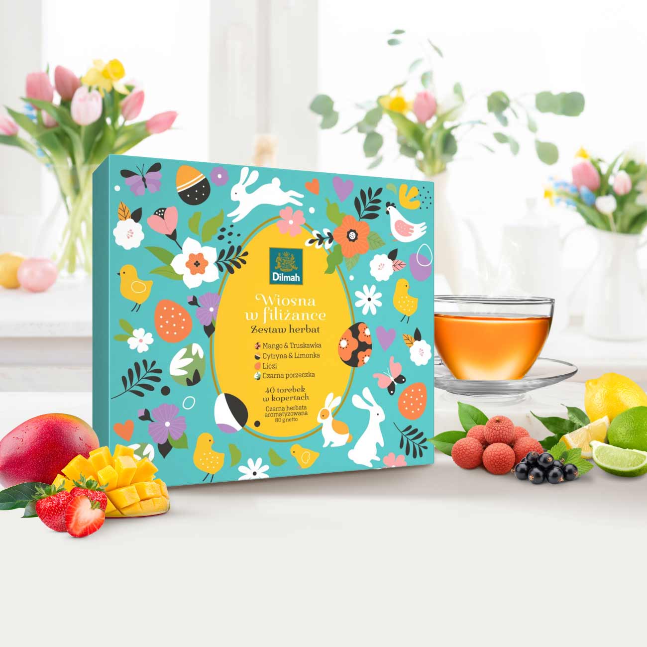 Zestaw herbat na Wielkanoc Dilmah Easter Gift Pack„Wiosna w filiżance”. W tle tulipany i owoce.
