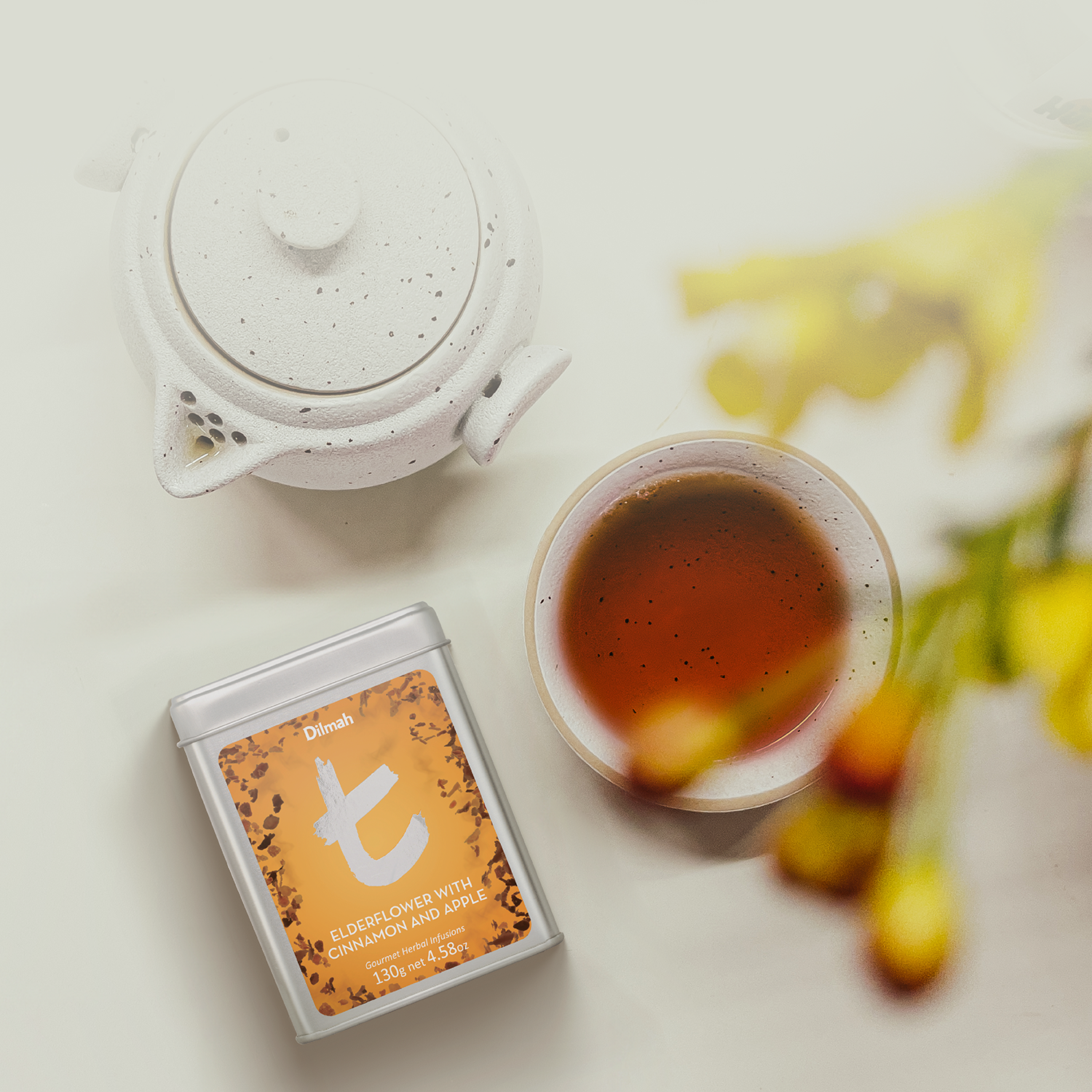 Herbata Dilmah Elderflower with Cinnamon and Apple, obok filiżanka I stylowy dzbanek.