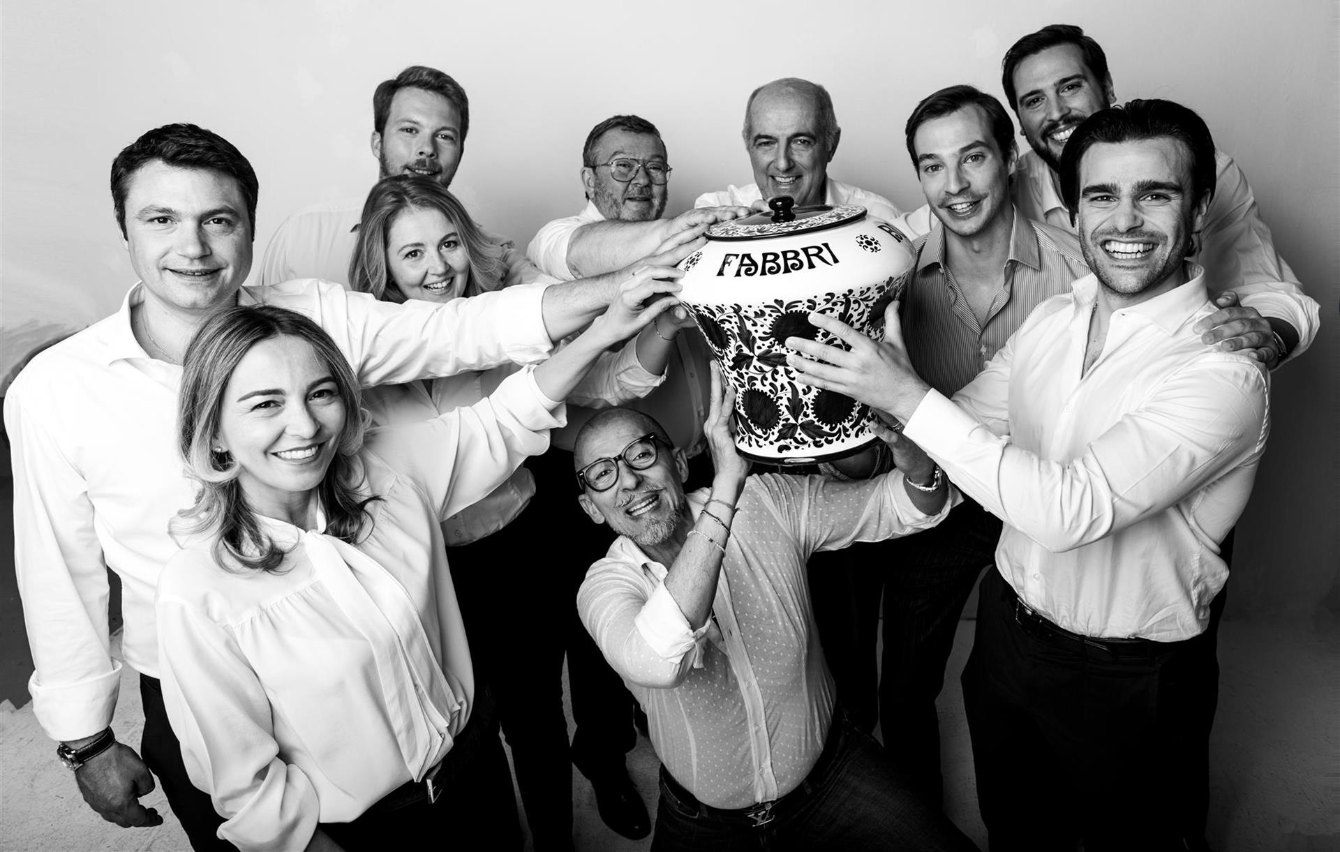 Rodzina Fabbri prezentująca swój kultowy produkt – wiśnie Fabbri Amarena w ikonicznym słoiku w stylu włoskiej porcelany.