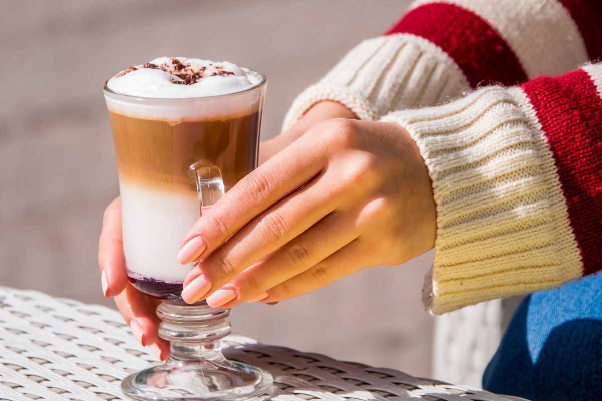 Kobieta prezentująca kawę smakową Cherry Cherry Latte Zero z syropem Fabbri Mixybar Amarena Zero.