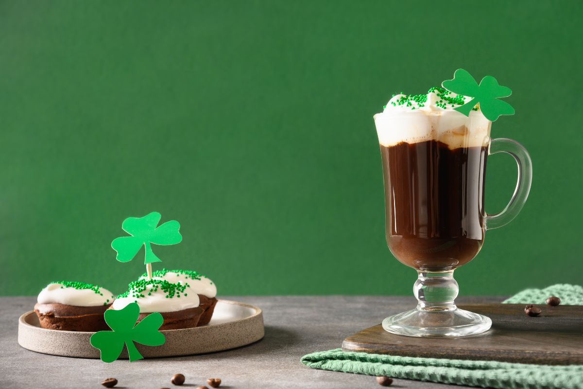 Kawa po Irlandzku na zielonym tle i z ozdobną koniczynką – symbolem Irlandii. 